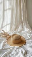 A hat sits on a bed with white sheets photo