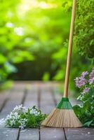 A broom and flowers on a wooden deck photo