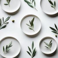 A group of white plates with green leaves on them photo