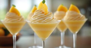 Four dessert glasses with whipped cream and orange slices photo
