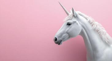 A white unicorn is standing against a pink background photo