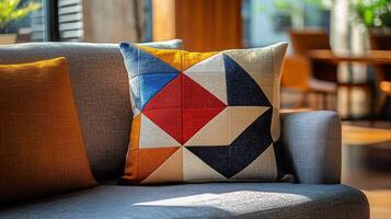 A colorful cushion sits on a couch photo