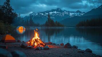 Campfire and tent in front of a lake at night photo