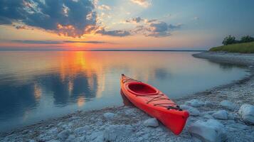 A red kayak on the shore of a lake photo