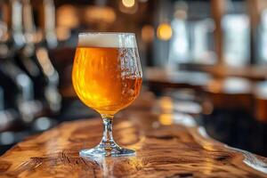 A glass of beer sitting on top of a wooden table photo