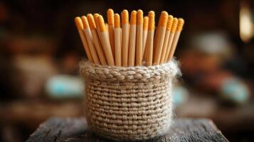 A crocheted container with wooden sticks in it photo