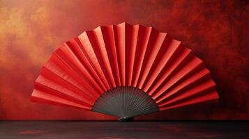 A red fan sitting on a red background photo