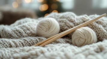 Two balls of yarn and knitting needles on a blanket photo