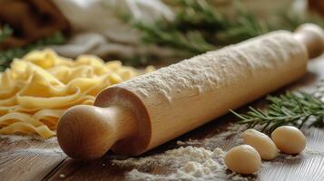 Pasta rolling pin and pasta on wooden table photo