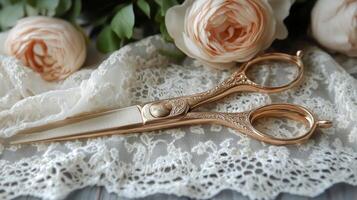 A pair of gold scissors on a lace table photo