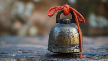 A bell with a red string tied to it photo