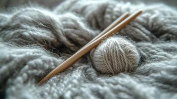 A pair of knitting needles and a ball of yarn photo