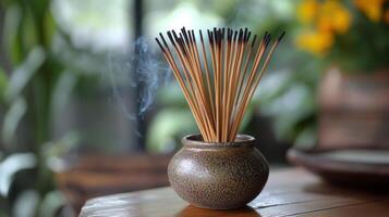 A vase with sticks of incense sticks sitting on a table photo