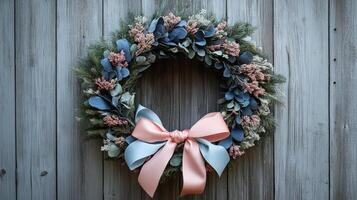 A wreath with blue and pink flowers on a wooden wall photo
