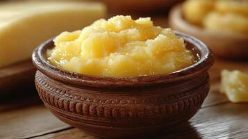 A bowl of butter and cheese on a wooden table photo