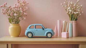 A small toy car is sitting on a table next to a vase of flowers photo