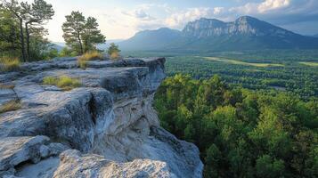 A rocky cliff with trees and grass on top photo