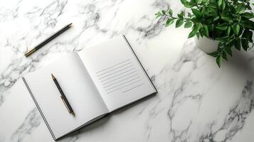 Notebook, pen and plant on marble table photo