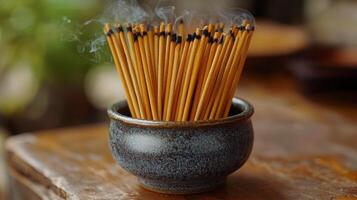 Incense sticks in a ceramic bowl on a wooden table photo