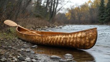 A canoe is sitting on the shore of a river photo