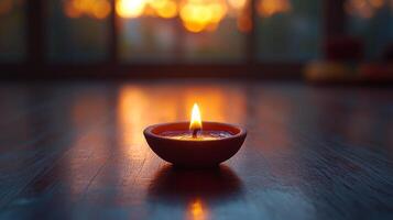 A small candle is lit on a wooden table photo