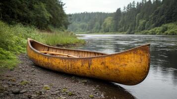 A canoe is sitting on the shore of a river photo