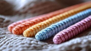 Four colorful yarn needles laying on a blanket photo