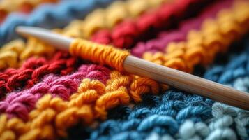 A crochet hook and yarn on a colorful blanket photo