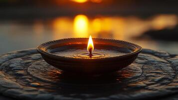 A candle is lit on a table in front of a lake photo