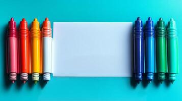 Colorful markers and blank paper on a blue background photo