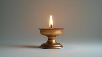 A golden candle is lit on a table photo