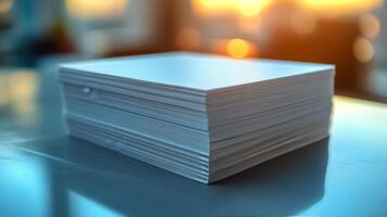 Stack of paper on a table with a blurry background photo