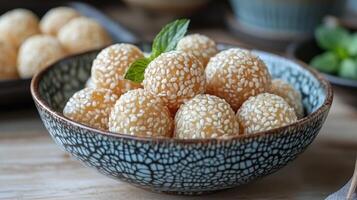 A bowl filled with sesame balls on a table photo