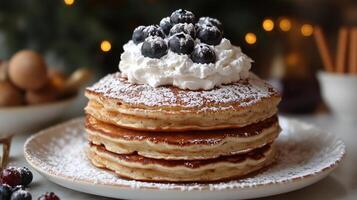 A stack of pancakes with blueberries and whipped cream photo