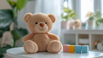 A teddy bear sits on a table next to blocks photo