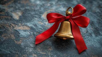 A golden bell with a red ribbon tied around it photo