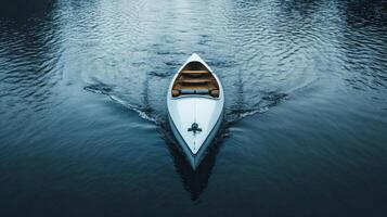 Serene canoe gliding over calm lake waters at dusk with gentle ripples surrounding photo