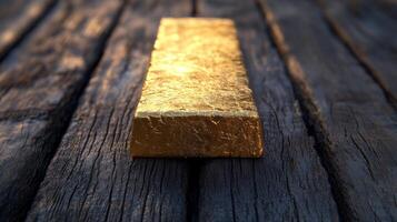 Gold bar resting on a wooden surface showcasing its shine and texture under natural light photo