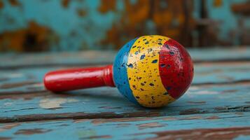 A colorful maraca sitting on a wooden table photo