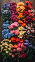 A large arrangement of colorful flowers on a wooden table photo