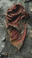 A red blanket on the ground with some debris photo