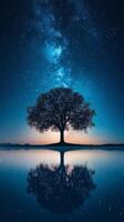 Majestic tree under the starry night sky reflecting in tranquil water photo