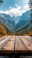 An empty wooden table in front of a mountain range photo