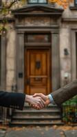 Two people shaking hands in front of a house photo