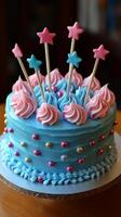 A blue cake with pink frosting and stars on top photo