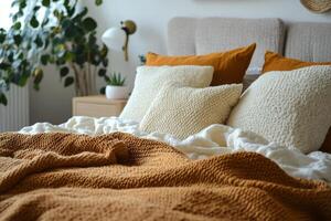 A bed with orange and white pillows and a plant photo