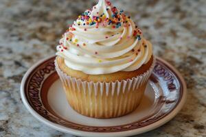 A cupcake with sprinkles on top on a plate photo