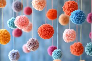 Colorful pom poms hanging from strings photo