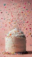 A cake with sprinkles and confetti falling from the top photo