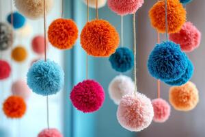 Colorful pom poms hanging from strings photo